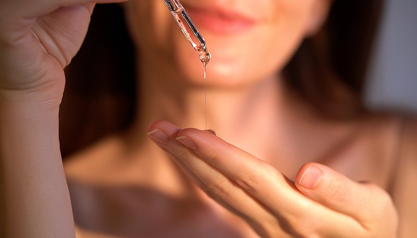 Aplicación de sérum facial con niacinamida con gotero sobre la palma de la mano.webp